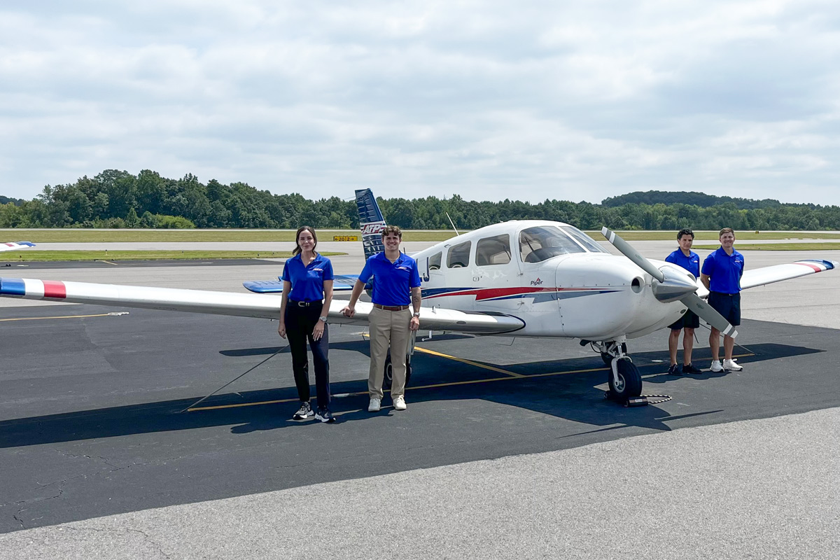 Four American Airlines Cadets standing next to a Cessna at ATP's Charlotte-Concord training center